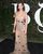 4. Selena Gomez mengenakan gaun transparan berwarna nude corak bunga