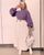 5. Tampil fun sweater ungu dimasukan ke dalam pleated skirt putih