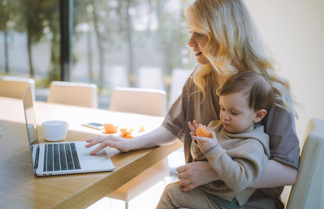 https://www.pexels.com/photo/woman-carrying-her-baby-and-working-on-a-laptop-4079281/