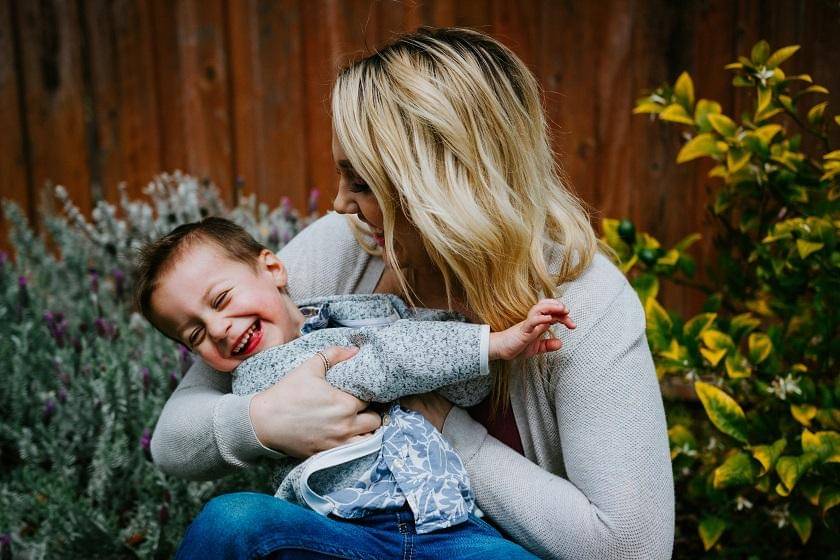 mom tickle baby - Unsplash/GabePierce