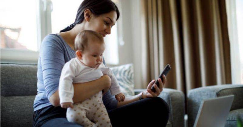 Ibu dan bayi yang sedang melihat ponsel - istockphoto