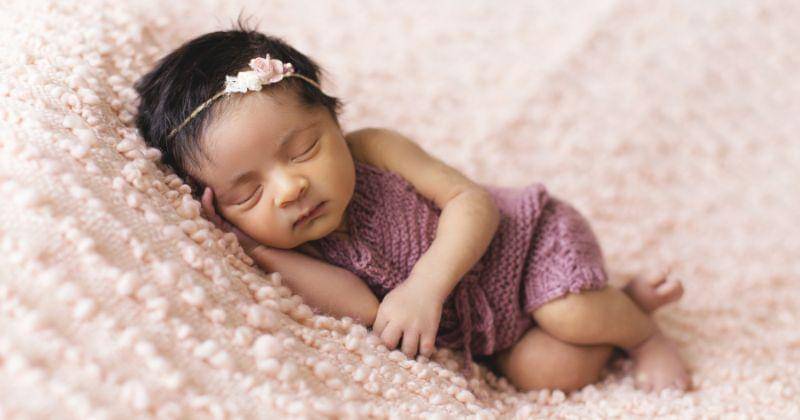 Bayi berbaring di karpet merah muda - Pexels/Shahbaz Akram