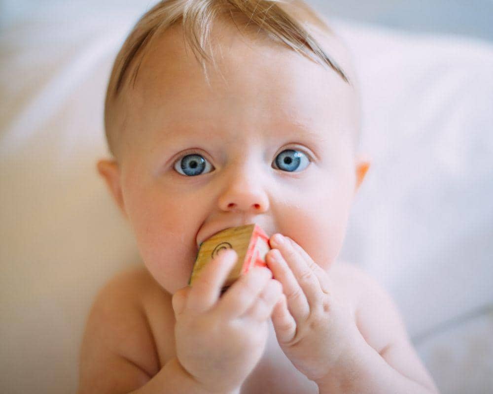 ilustrasi bayi menggigit mainan karena sedang tumbuh gigi atau teething (unsplash.com/Colin Maynard)