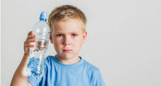Anak memegang botol air mineral