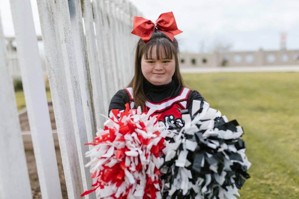 Anak perempuan dengan down syndrome, berbakat menjadi cheerleader.