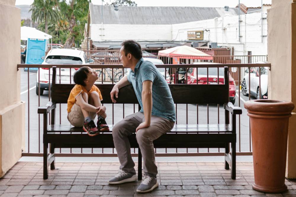 Ayah dengan anak down syndrome sedang mengobrol satu sama lain