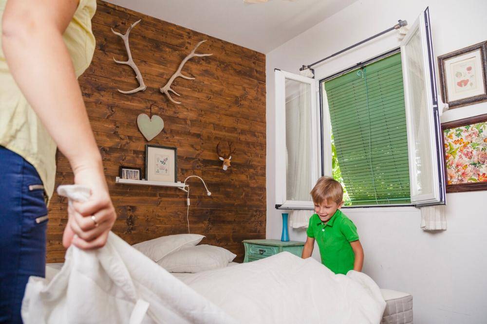 Anak merapikan tempat tidur