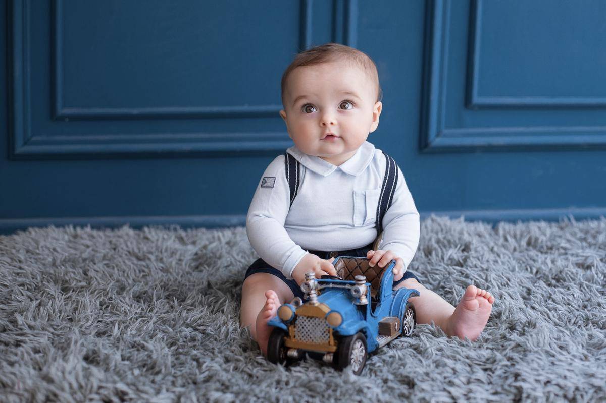 blonde-toddler-sitting-carpet-playing-with-blue-car.jpg