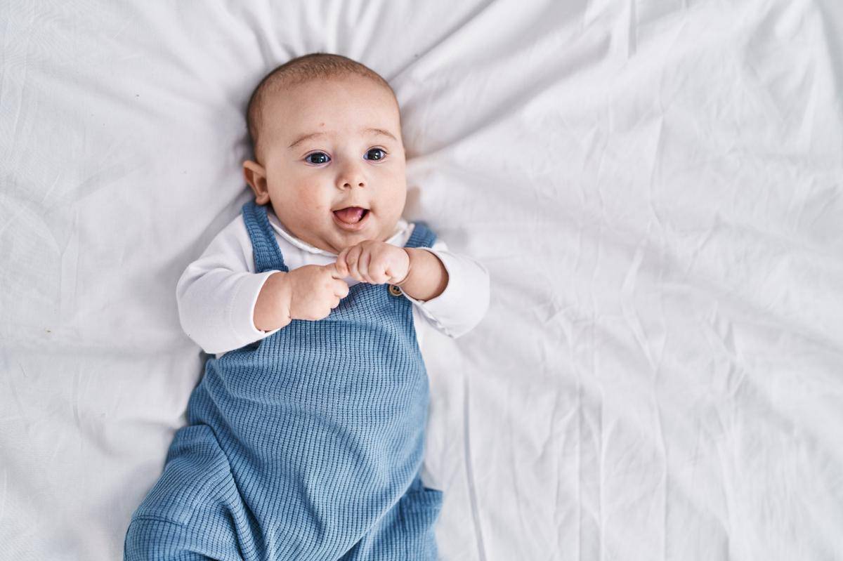 adorable-baby-smiling-confident-lying-bed-bedroom.jpg