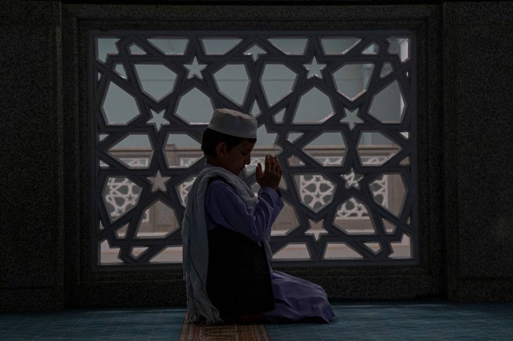Anak sedang salat di petang hari