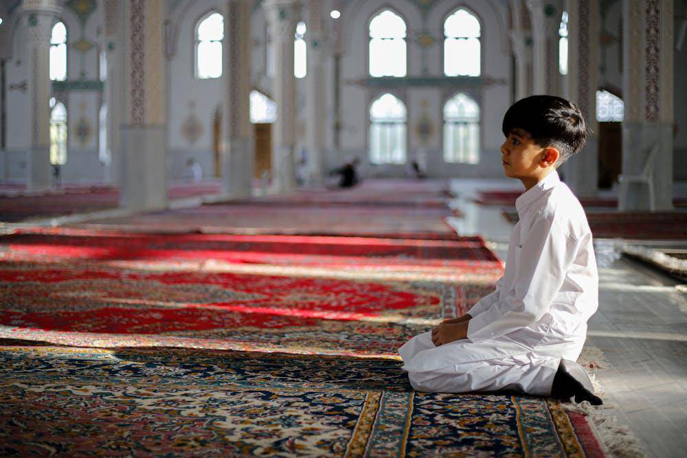 anak laki-laki salat di masjid