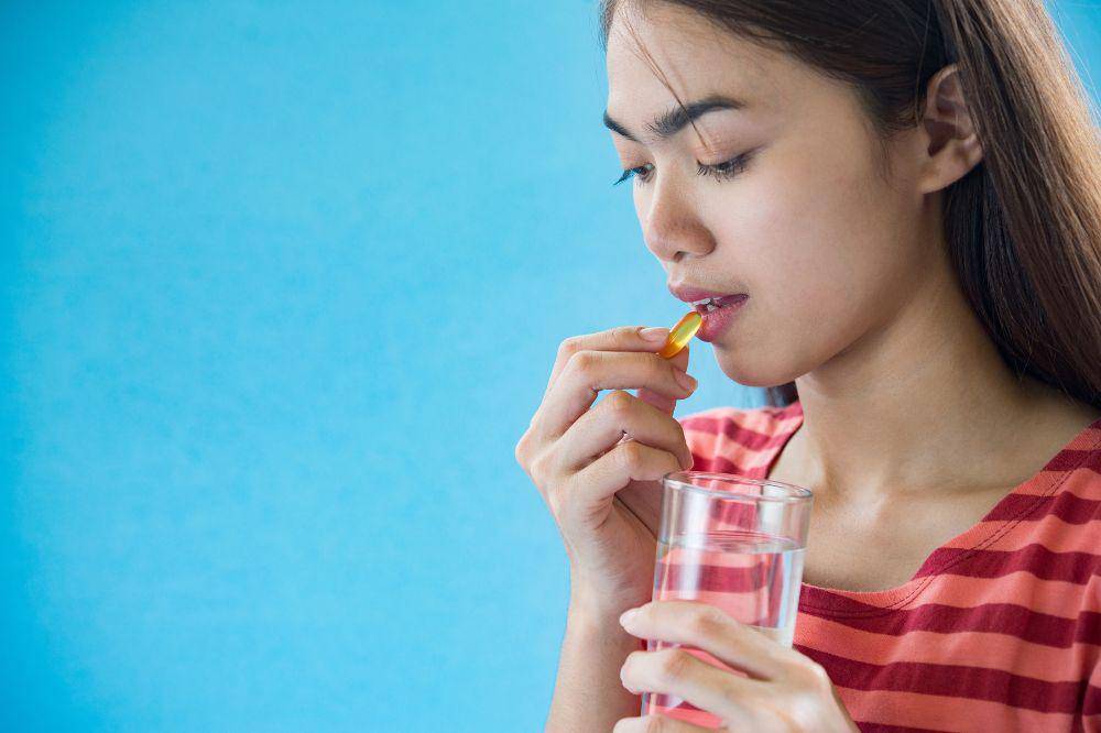 perempuan minum vitamin.jpg