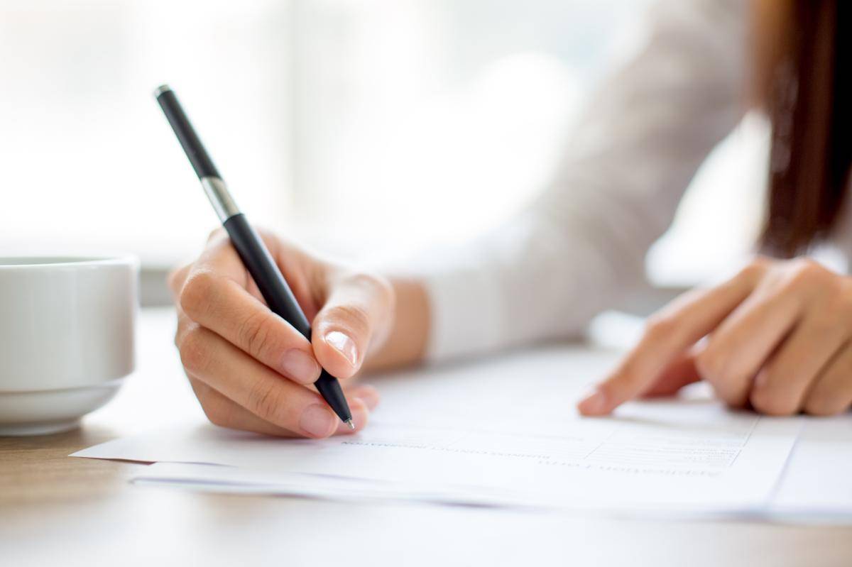 hand-businesswoman-writing-paper-office.jpg
