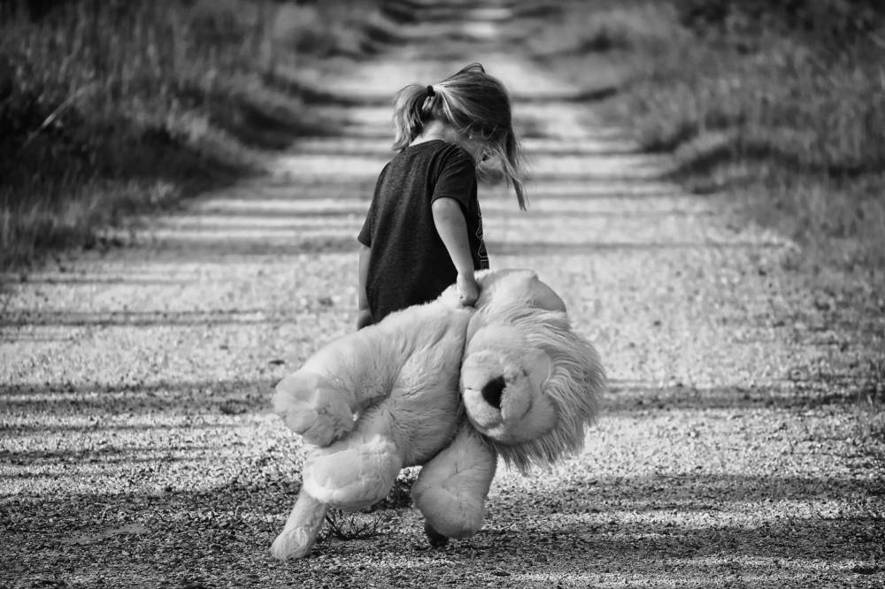 Anak berlari membawa boneka
