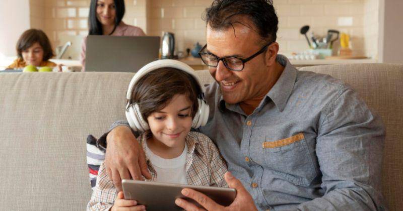 parents with kids playing gadget together
