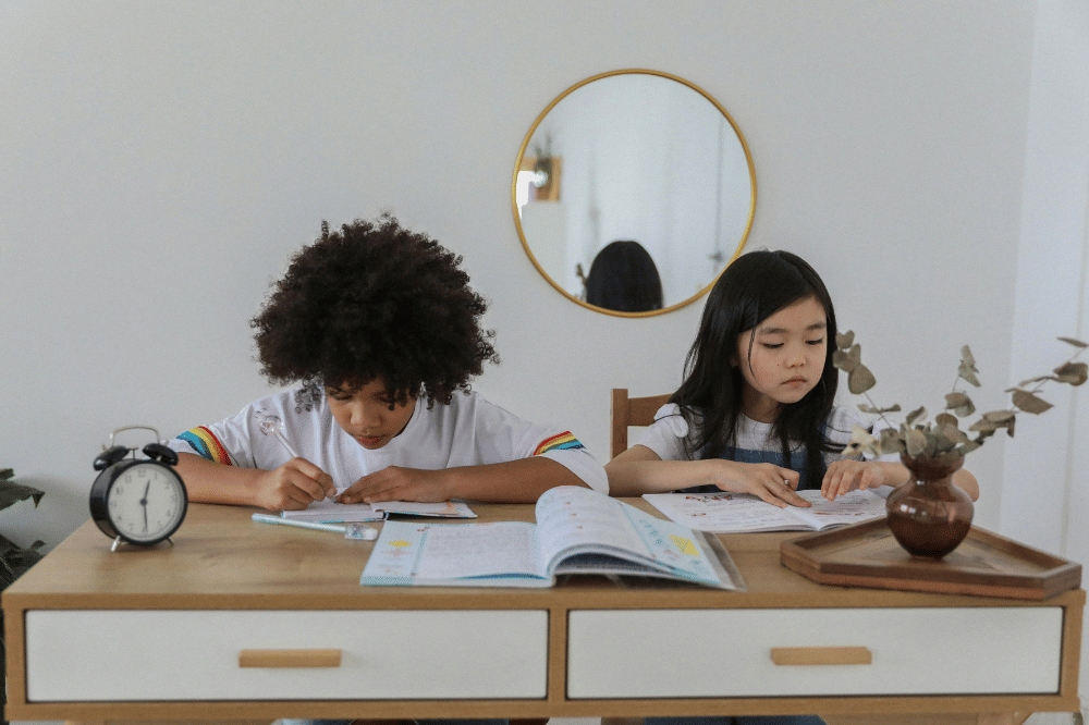 Kedua anak mengerjakan dengan jam di sampingnya