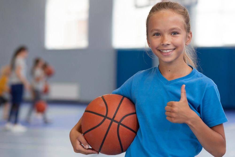 Anak perempuan memgang bola basket