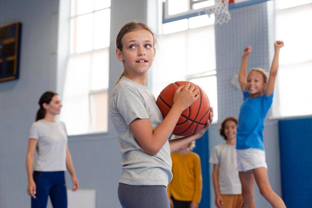 Anak perempuan memegang bola basket