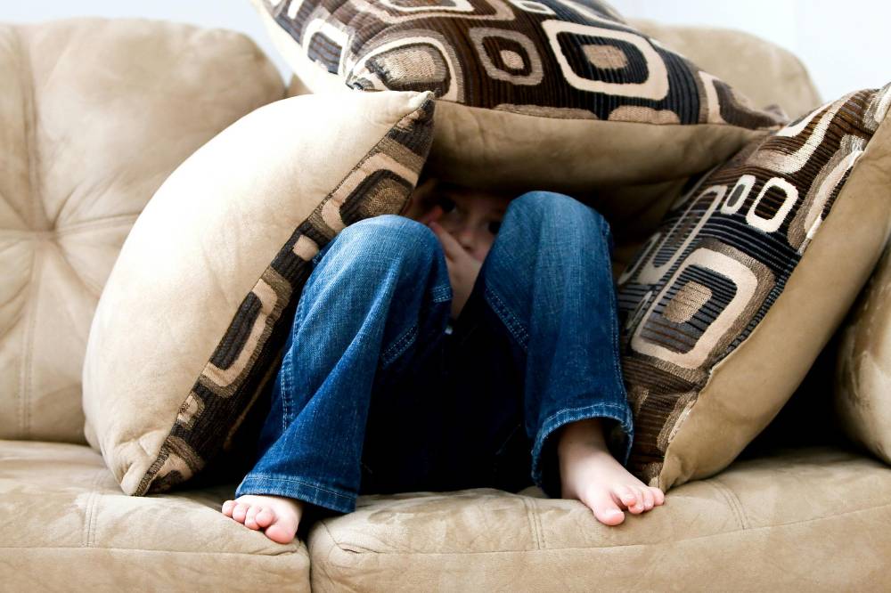 Anak bersembunyi di tengah bantal