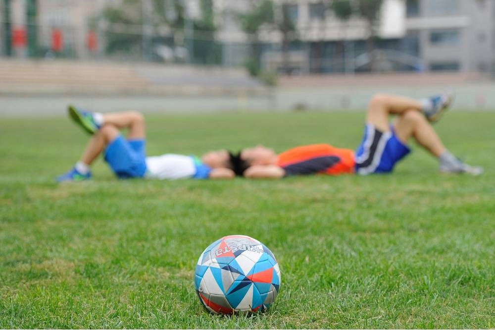 Kedua anak tidur di lapangan sepak bola.