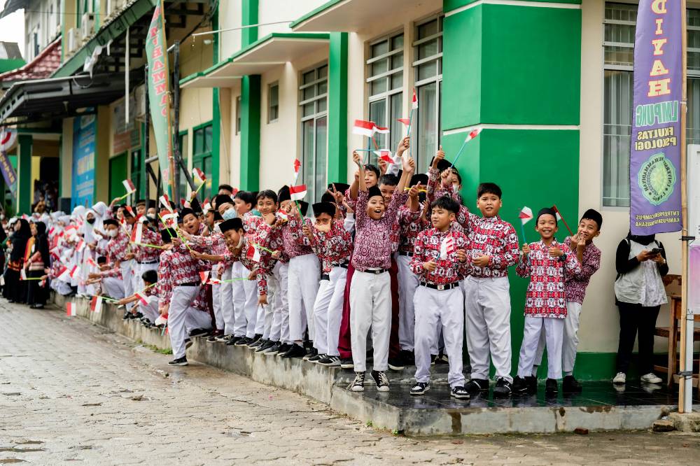 Anak-anak melambaikan bendera