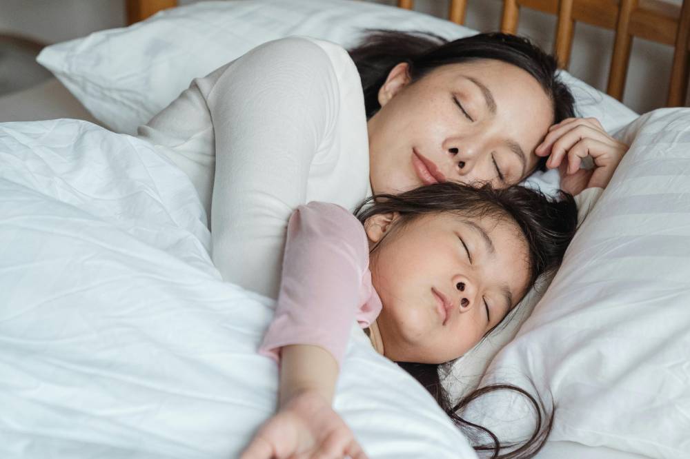 Ibu memeluk anak sedang tidur