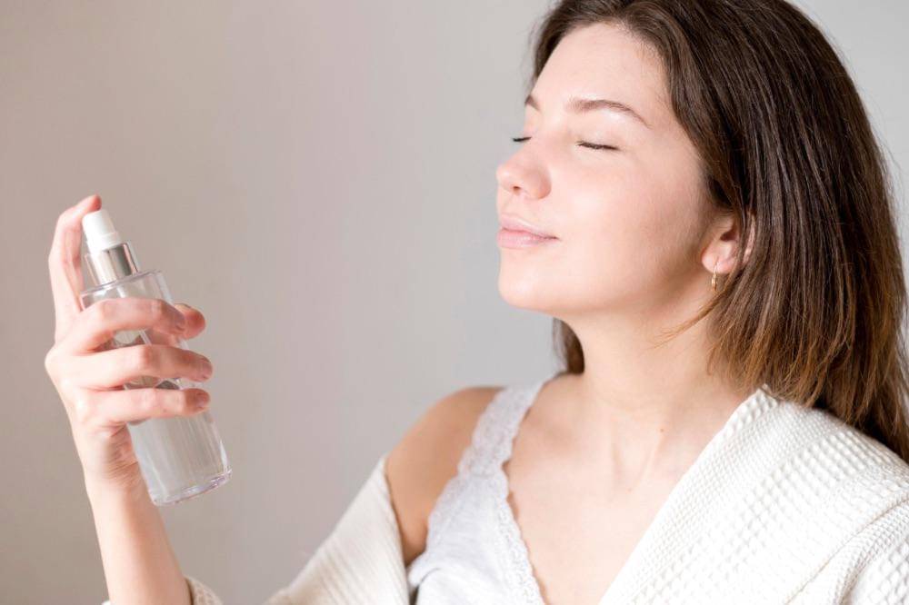 Perempuan sedang memakai face mist