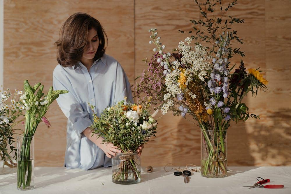 woman in white dress shirt holding bouquet of flowers
