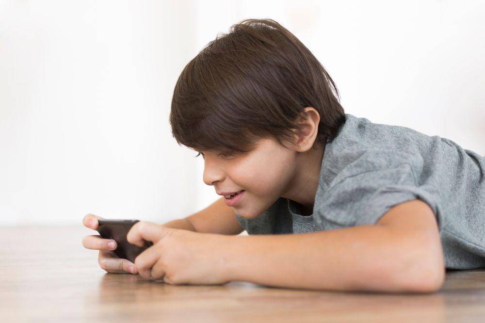 Anak laki-laki bermain handphone