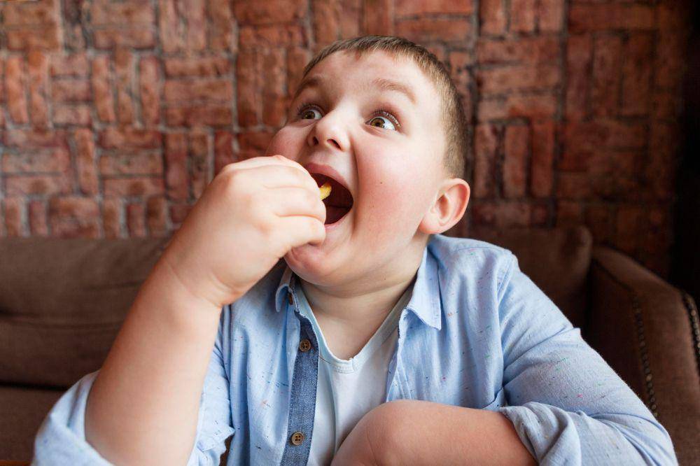 Anak laki-laki sedang makan kentang