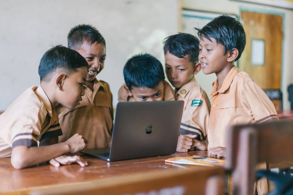 Anak SMP berkumpul di depan laptop