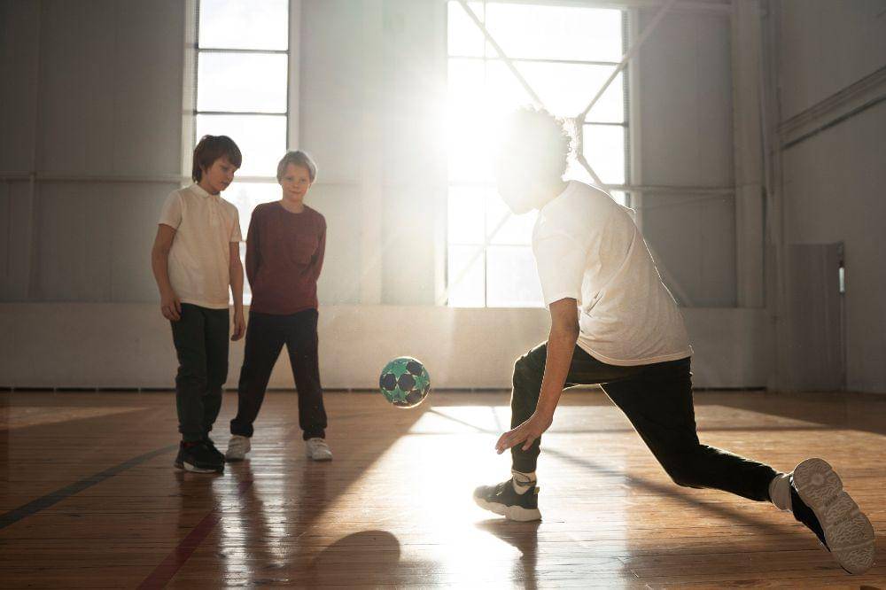 Anak-anak bermain sepak bola di sekolah