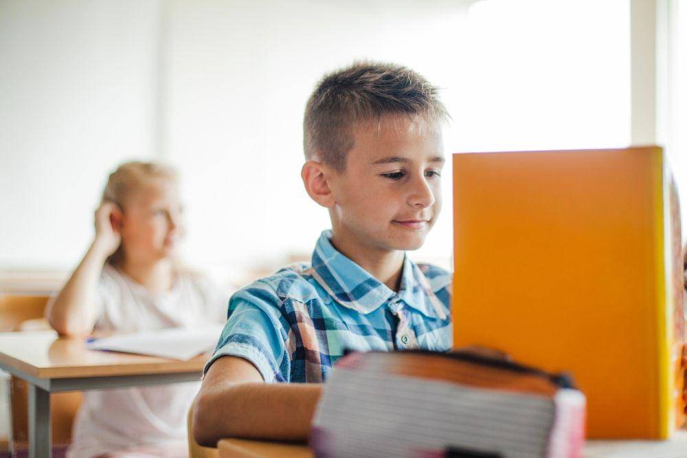 anak membaca buku di kelas