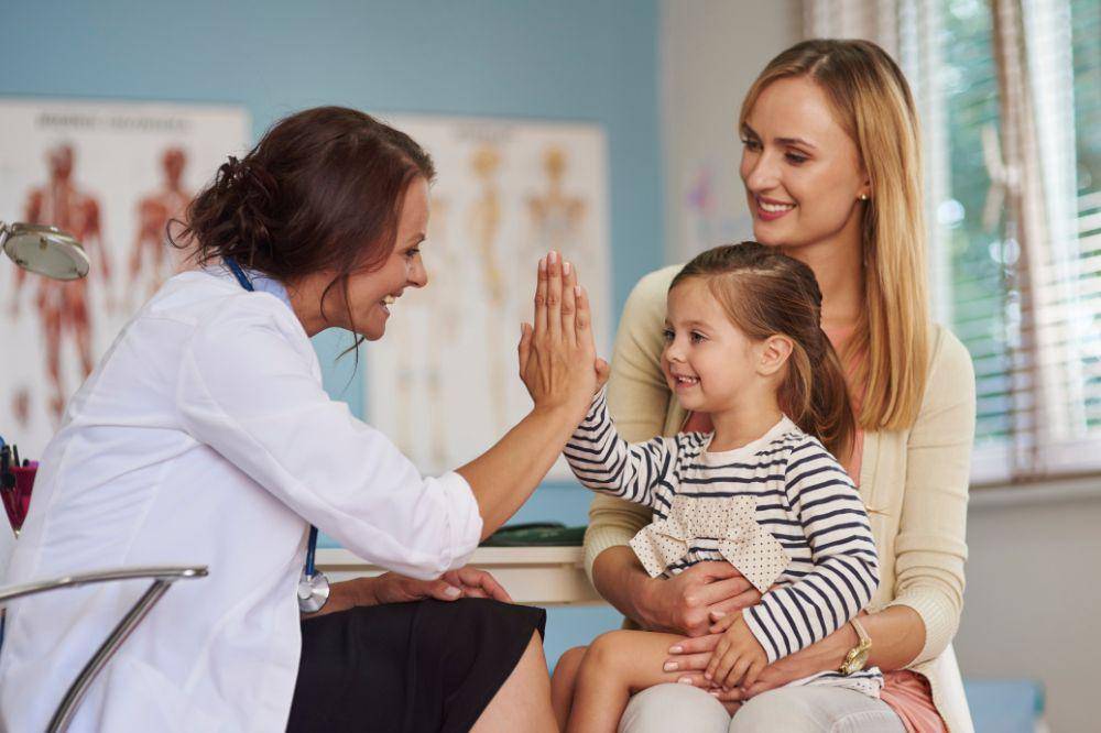 Doctor giving a high five to a smiling girl