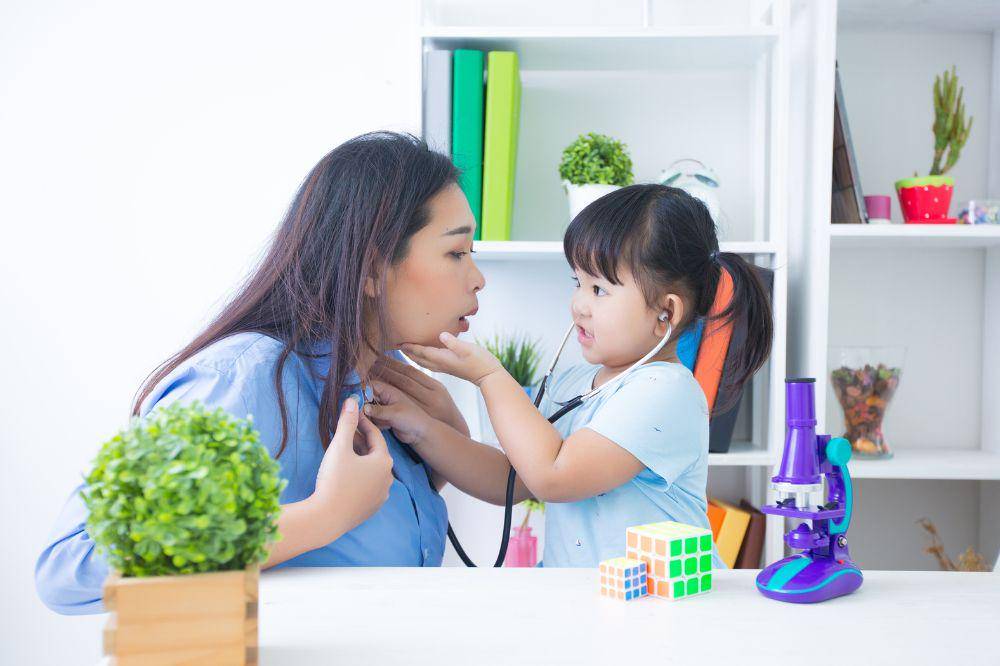 Mother and daughter playing doctor with stethoscope