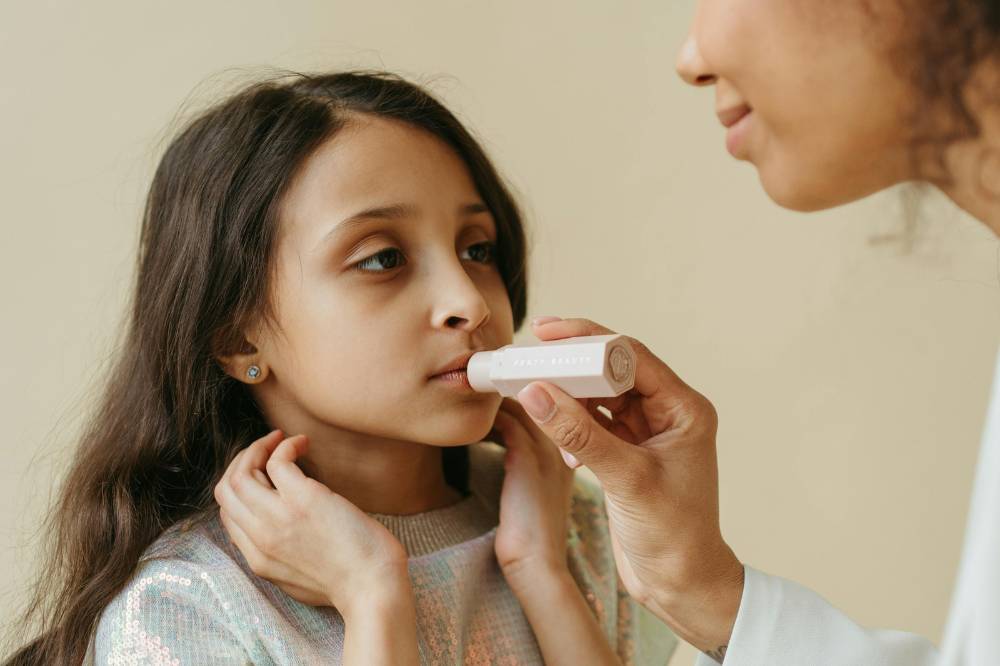 Anak perempuan memakai lipgloss