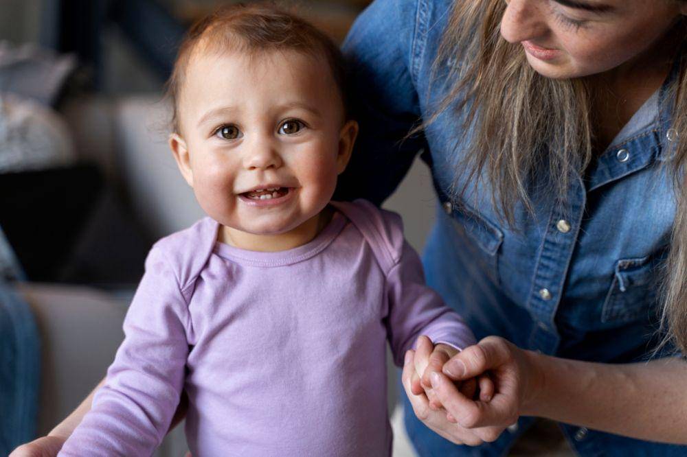 Adorable baby being held by his mother