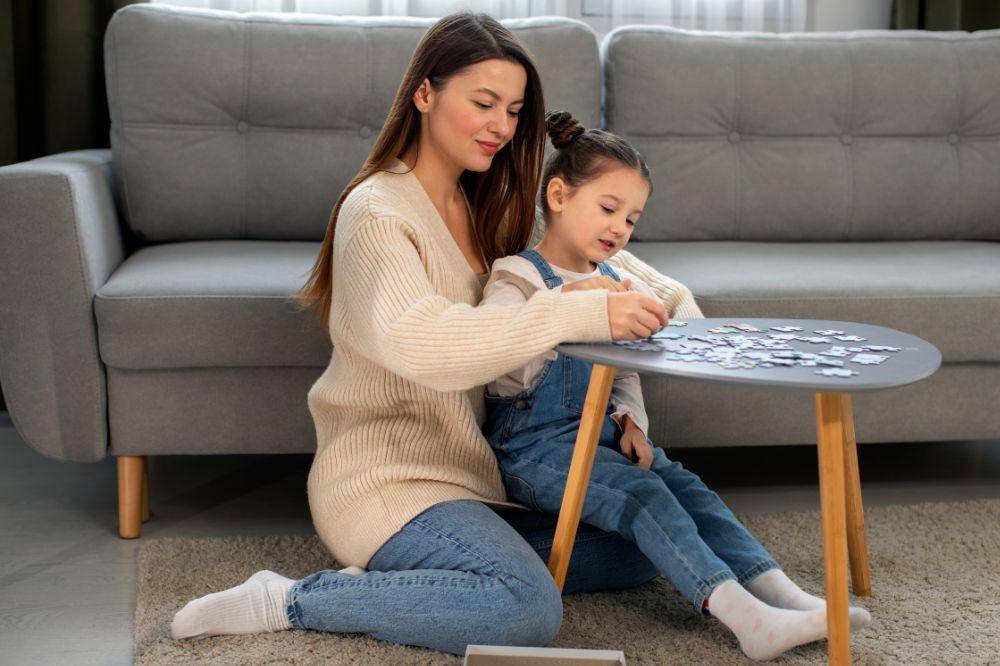 Full shot mother and girl playing game.