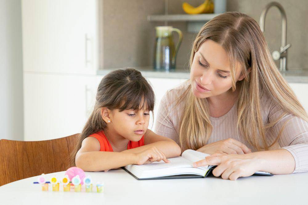 mom reading book with daughter
