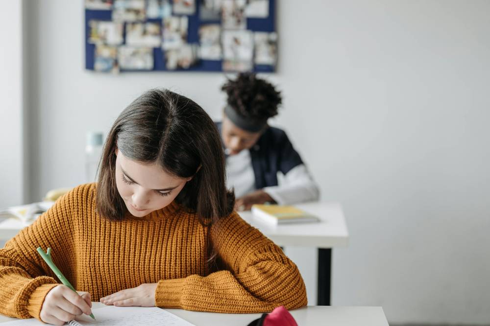 Anak mengerjakan tugas di kelas dengan tenang