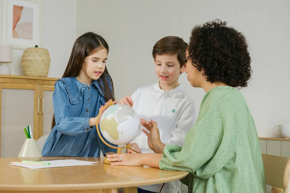 Guru menjelaskan globe ke dua anak