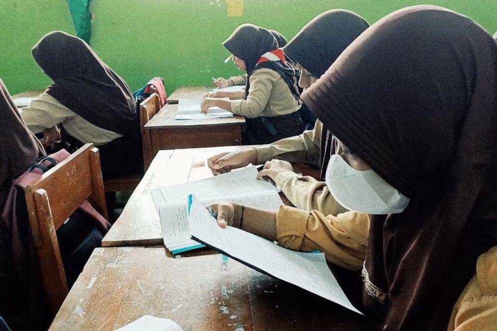 Anak sekolah sedang belajar di kelas