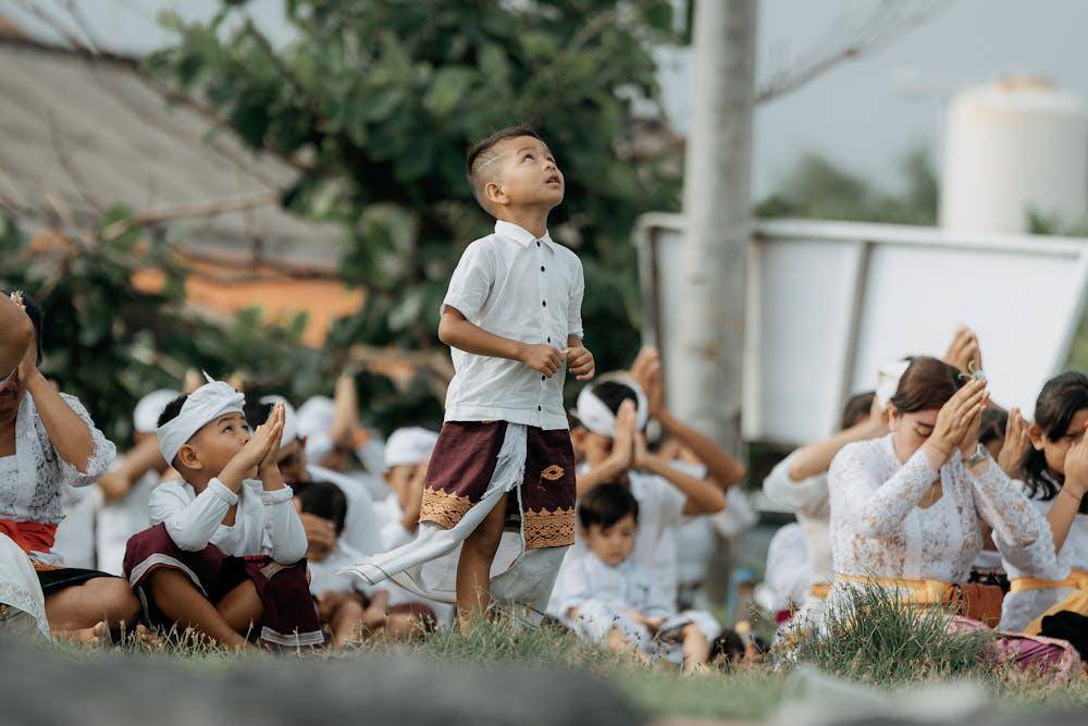 children praying on grass