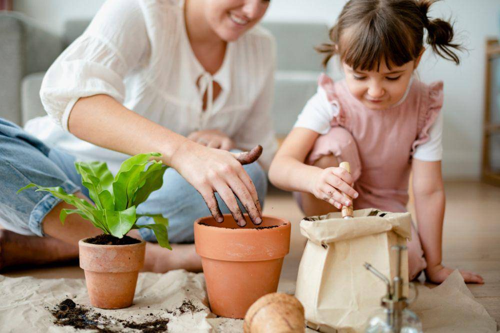 Kid potting plant at home