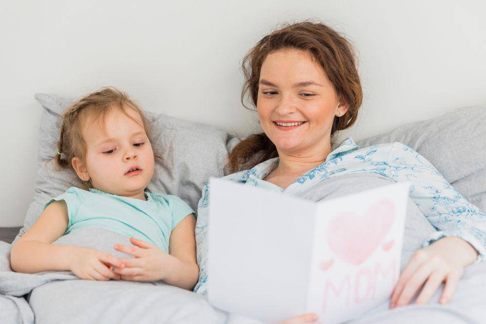 mother reading greeting card near her daughte
