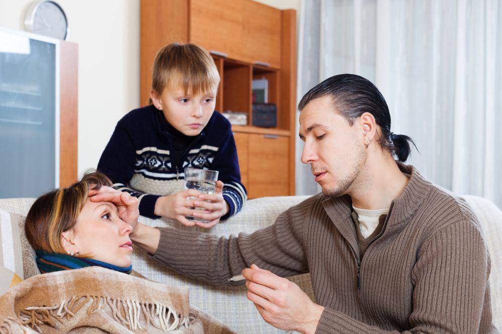 Man measuring the temperature of ill wife