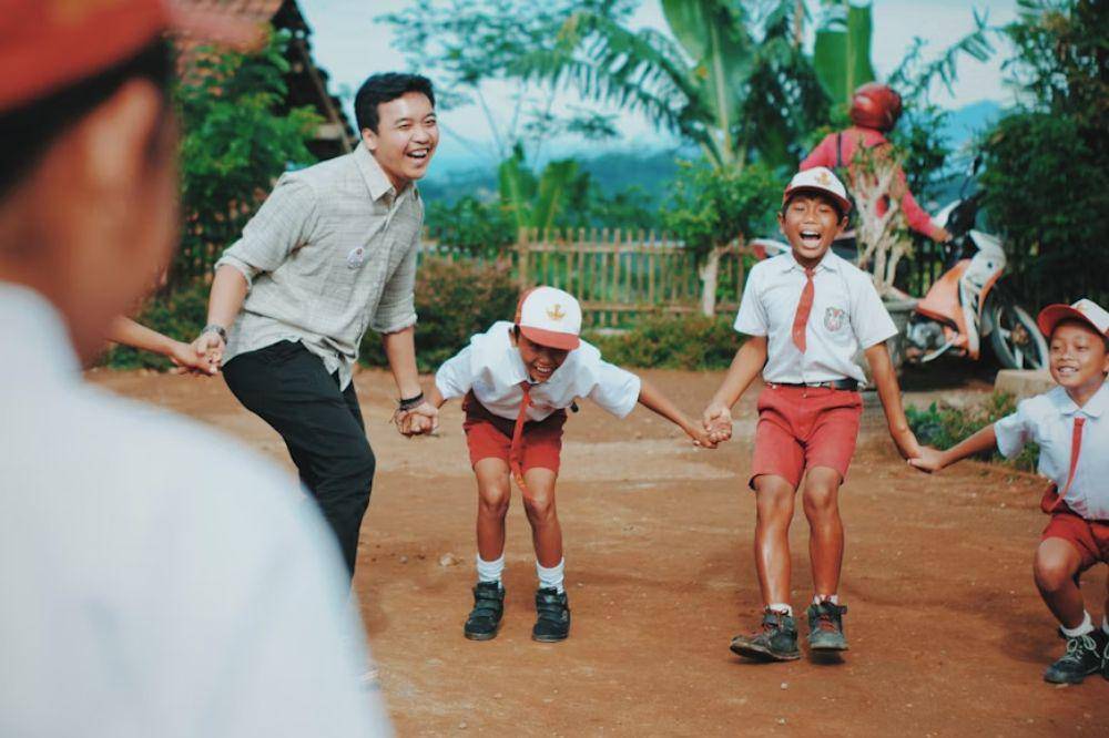 Guru dan para murid sedang bermain