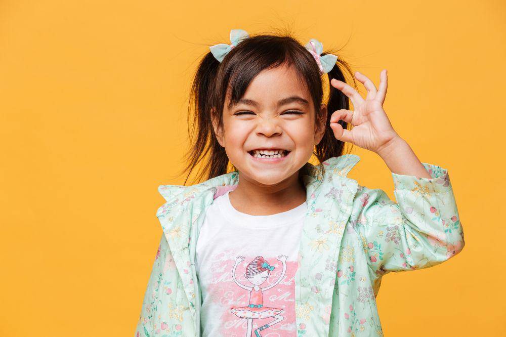Happy little girl child showing okay gesture