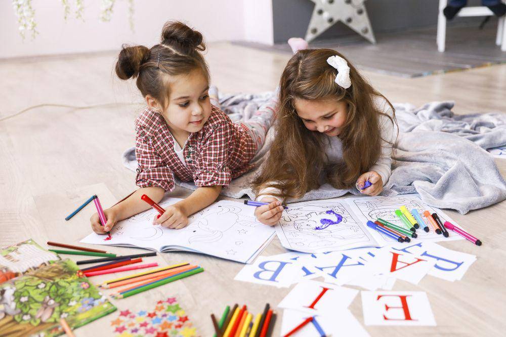 Two tiny girls which are drawing