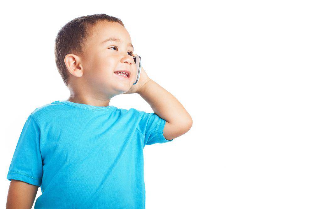 Little boy smiling while talking on a phone